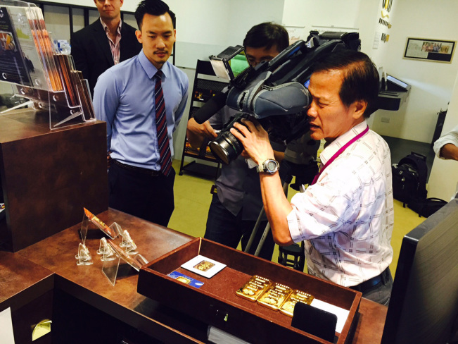 Channel 8 cameraman gets a close-up of our 100 gram BullionStar gold bars minted by Argor-Heraeus.