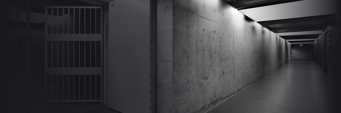 Dimly lit concrete corridor with a steel security gate inside Le Freeport Singapore