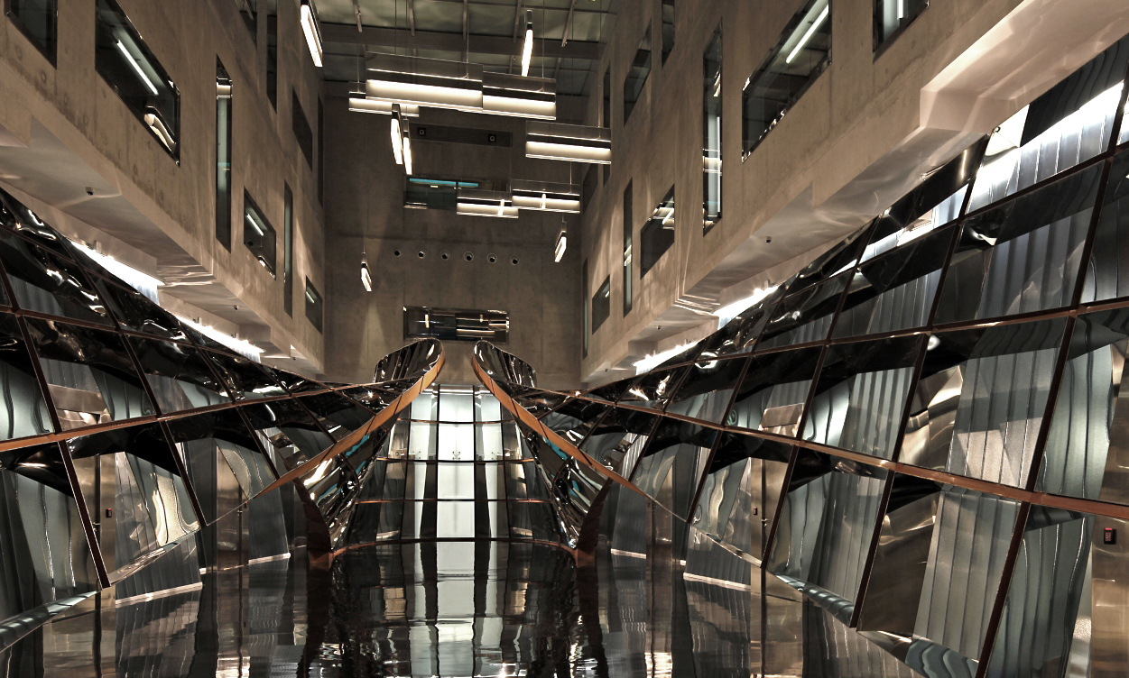 Wide view of La Cage Sans Frontière by Ron Arad, the reflective steel sculpture in the central atrium lobby of Le Freeport Singapore