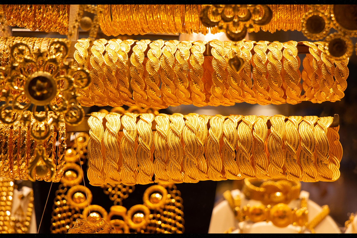 Rows of intricate yellow 22K gold bangles and jewelry on display in a traditional gold souk