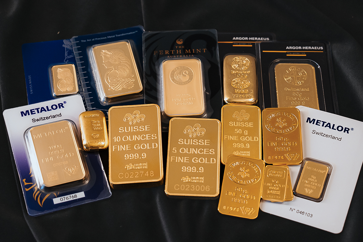 Assortment of gold bars in different troy ounce and gram weights including PAMP 10 oz and 5 oz bars, Metalor 100g bars, Perth Mint 50g bars, and Argor-Heraeus bars
