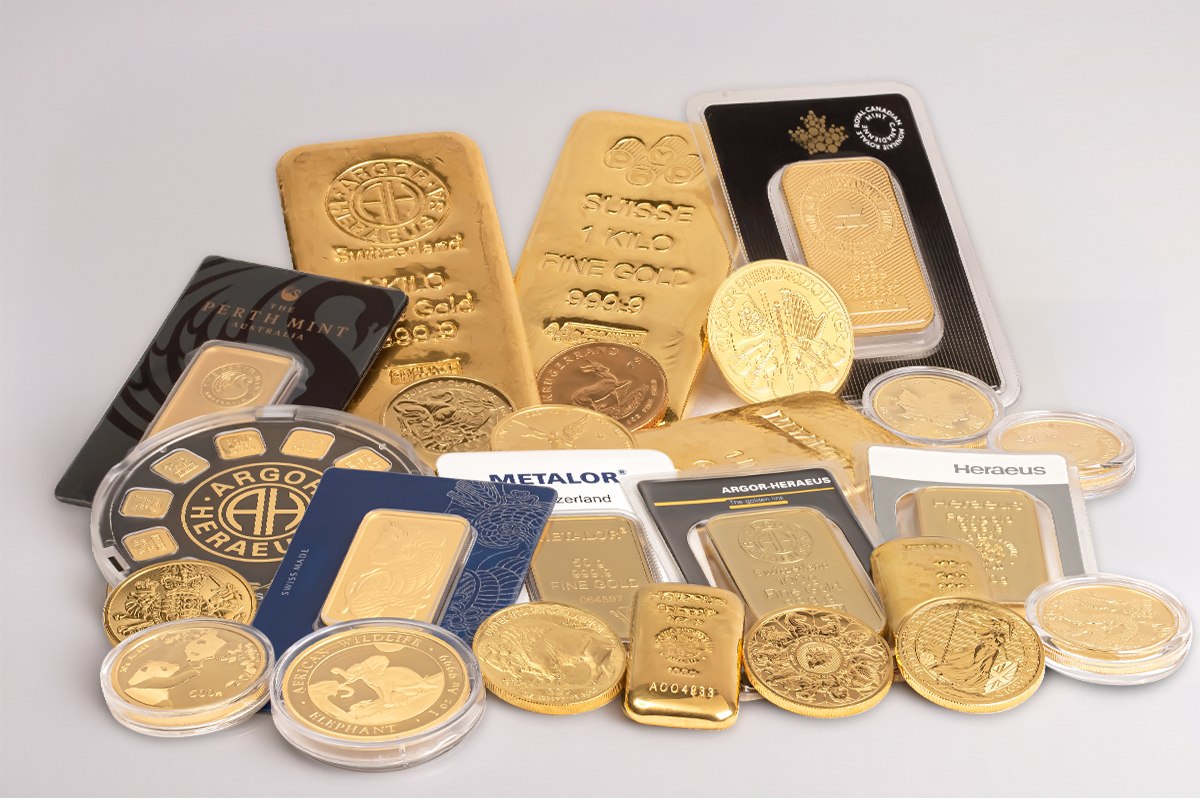 Assorted gold bullion bars, coins, and jewellery piled together, including kilo bars and minted 100-gram bars