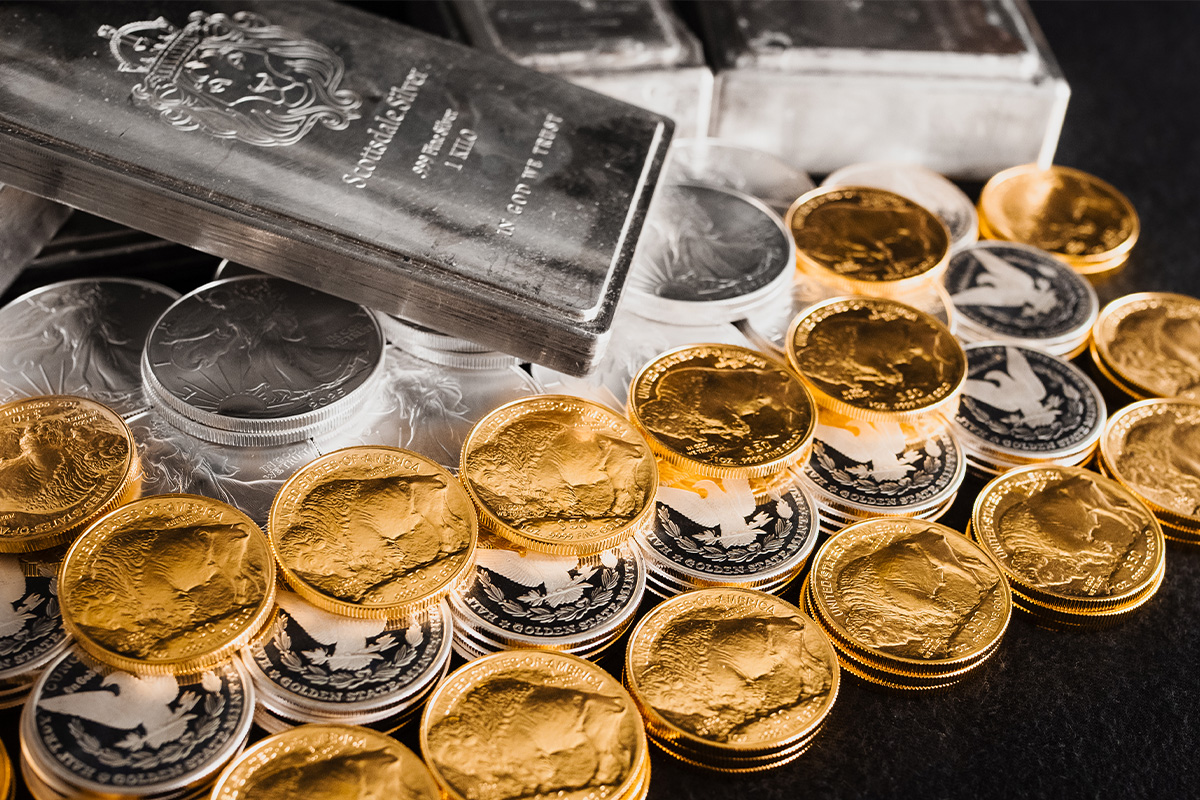 Stacks of gold coins with a bison design and "UNITED STATES OF AMERICA" inscription in front of silver bars and coins, including a bar reading "IN GOD WE TRUST"