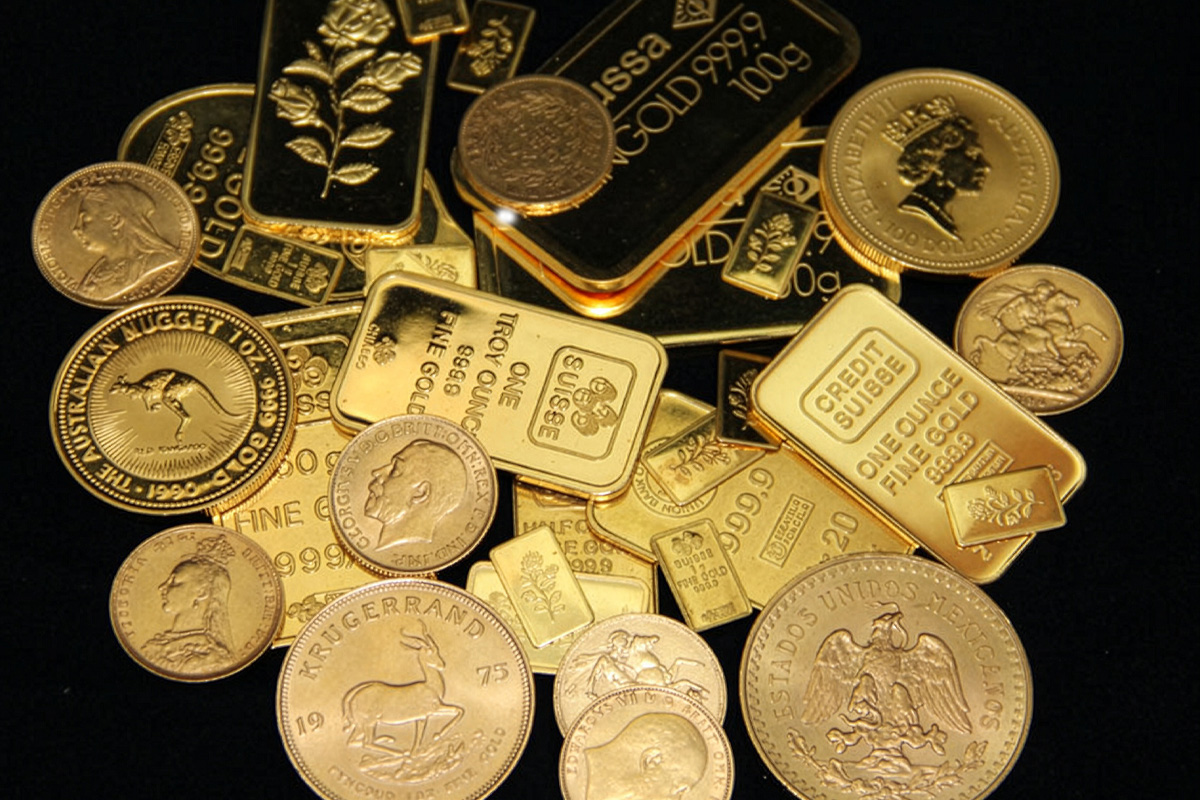 A pile of gold coins and bars including a 1975 Krugerrand, an Australian Nugget 1oz coin, a Mexican coin, a Credit Suisse one ounce fine gold bar, and several smaller stamped gold bars