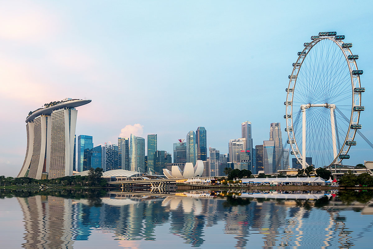 Singapore Marina Bay skyline at dusk showing Marina Bay Sands, the ArtScience Museum, and the Singapore Flyer reflected in the water