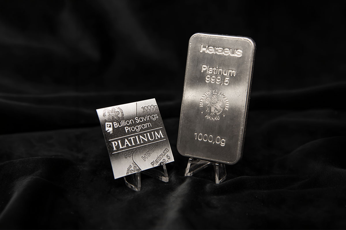 BullionStar Bullion Savings Program platinum card labelled 1000g displayed next to a Heraeus 1000 gram platinum bar